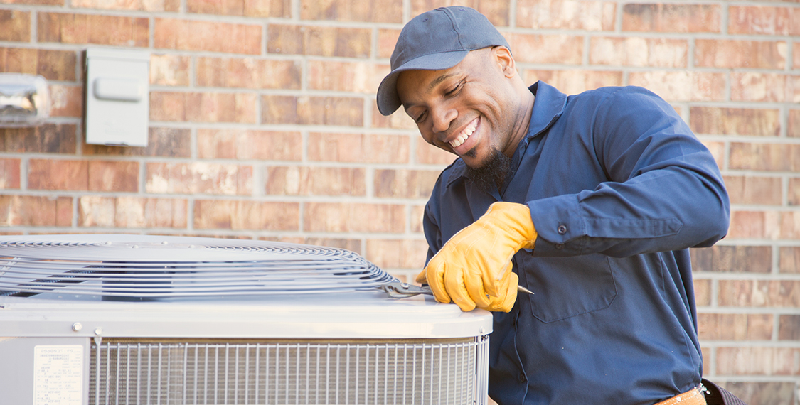 HVAC technician working on an outdoor condenser unit